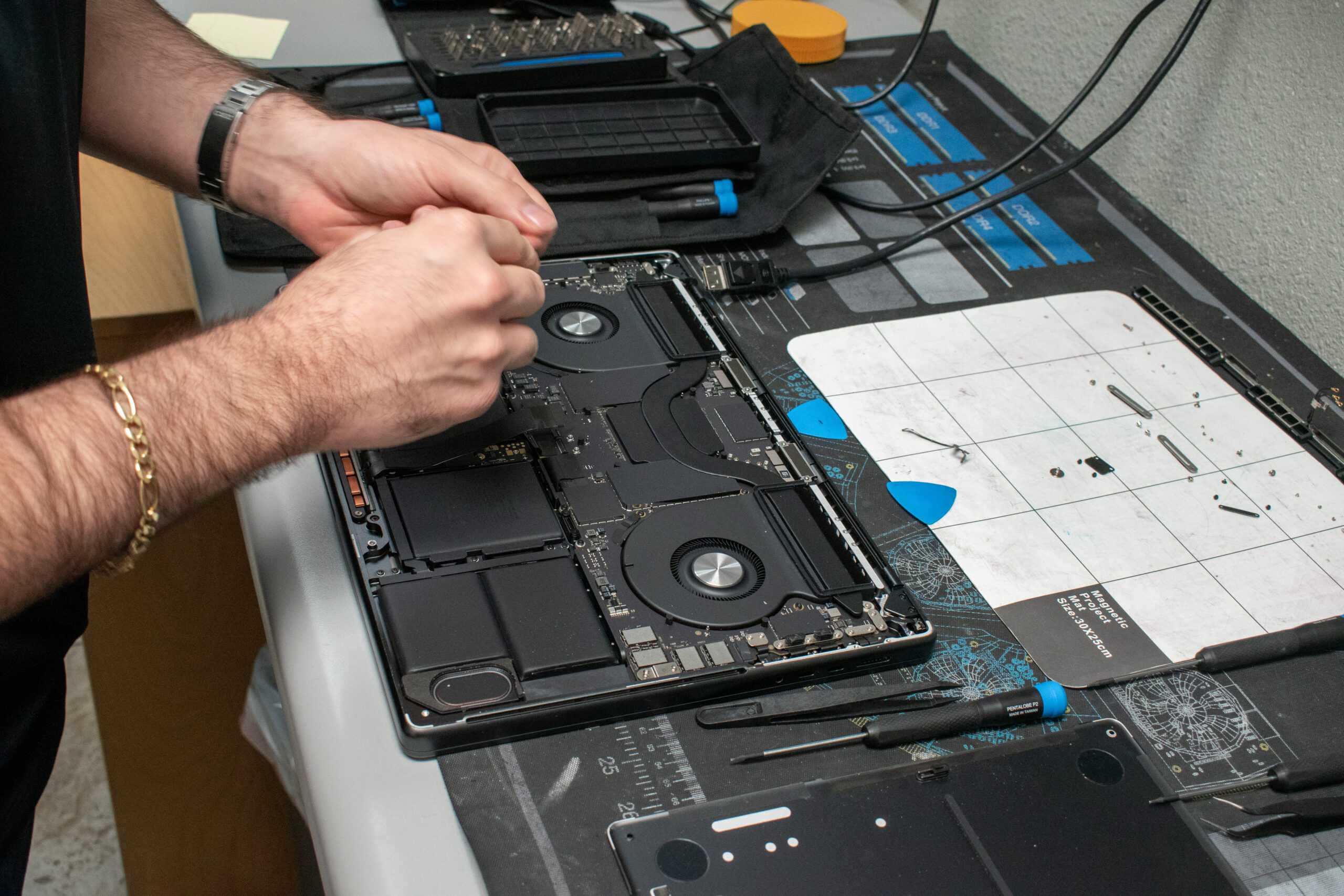 A technician carefully repairing a modern device with specialized tools at GenTech